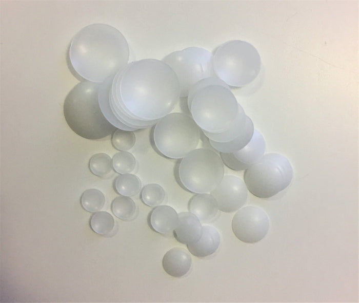 A collection of various sized transparent plastic domes arranged on a surface.