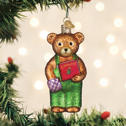 Corduroy bear glass ornament in green overalls holding a red book