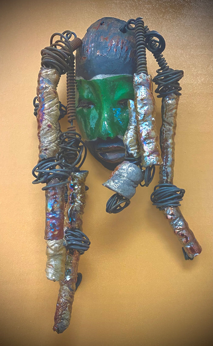 Meet Craig! I am going to make more with colors in the face like Craig. I like how the green and copper complements each other.  I started making art soon after seeing authentic African artwork at the Smithsonian Museum of African Art. I was in total awe. Craig was inspired by my visit there.  Craig is   4"x 10" and weighs 12 ozs. He has a two tone  green and copper face. Craig has hand coiled 16 gauge wire  hair with over  10 metallic raku beads.