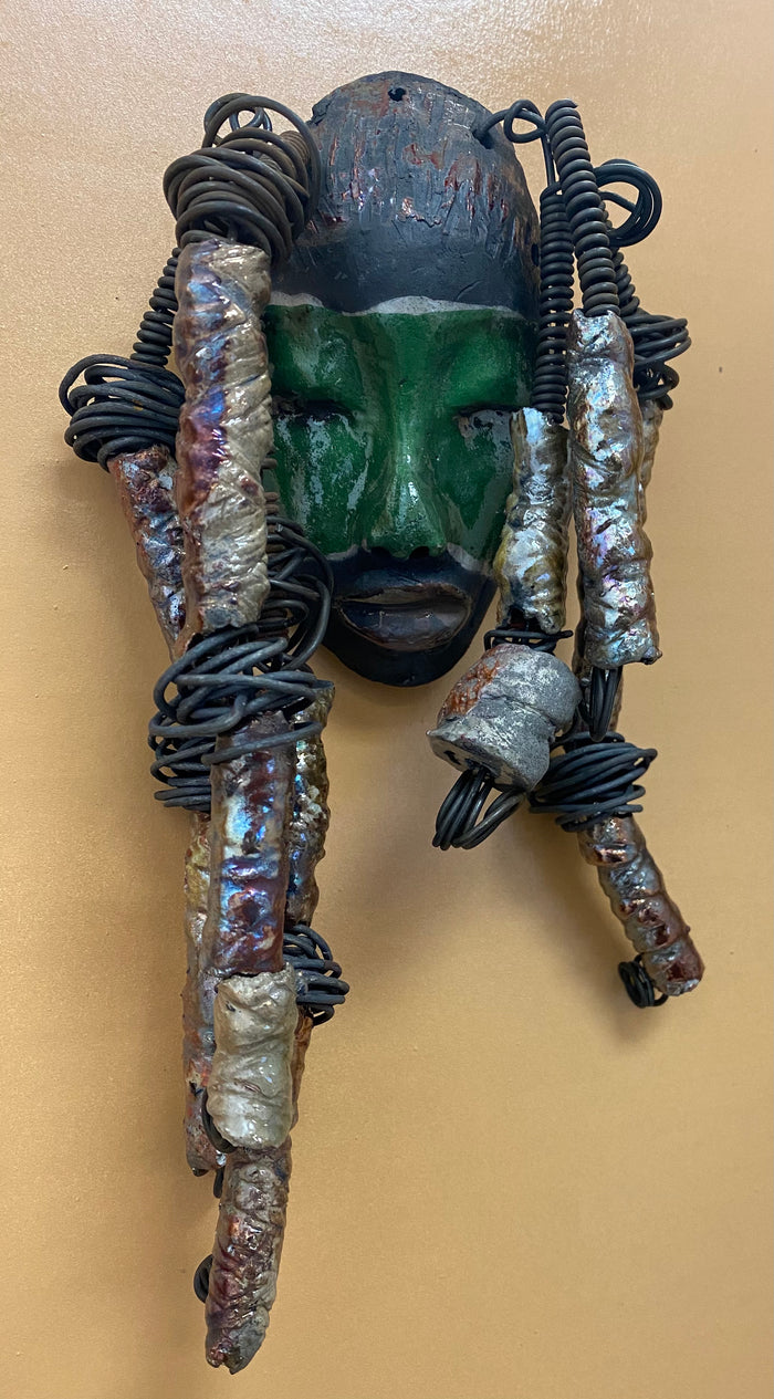 Meet Craig! I am going to make more with colors in the face like Craig. I like how the green and copper complements each other.  I started making art soon after seeing authentic African artwork at the Smithsonian Museum of African Art. I was in total awe. Craig was inspired by my visit there.  Craig is   4"x 10" and weighs 12 ozs. He has a two tone  green and copper face. Craig has hand coiled 16 gauge wire  hair with over  10 metallic raku beads.