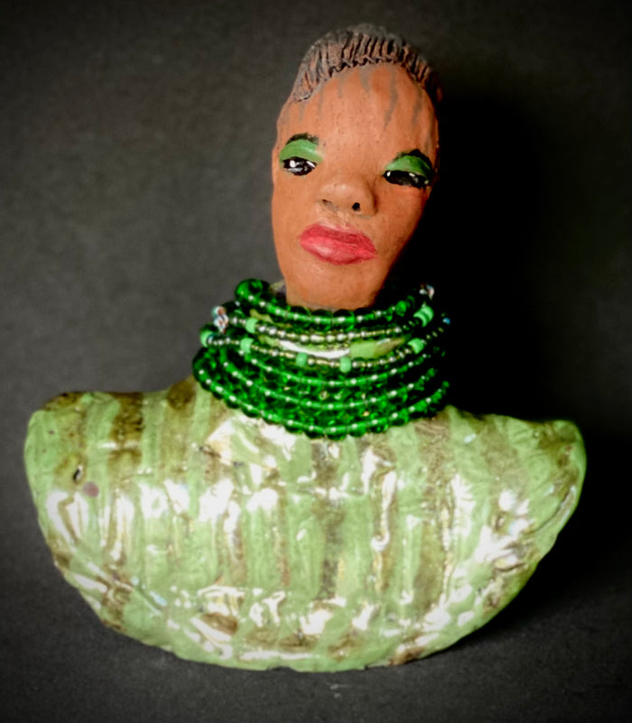 Delia looks up with joy and anticipation! Delia stands 7"x 6" x 3" and weighs 1.50 lbs. She wears an awesome metallic green textured copper robe. Delia has braided clay hair up in a bun. She has a honey brown complexion. Delia could make an excellent gift for your BFF! Delia will make for great conversation in your home. Free Shipping! Check out our Shipping  and Return policy