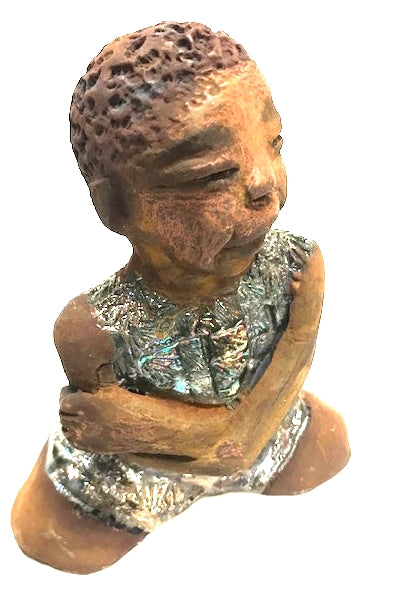 Eddie is a Wise Guy! See the wisdom in his face? Eddie stands 7" x 6" x 3" and weighs 1 lb. He has a shimmery copper over-sized shirt. Eddie complexion is honey brown. His arms are folded as he ponders!
