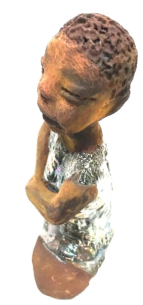Eddie is a Wise Guy! See the wisdom in his face? Eddie stands 7" x 6" x 3" and weighs 1 lb. He has a shimmery copper over-sized shirt. Eddie complexion is honey brown. His arms are folded as he ponders!