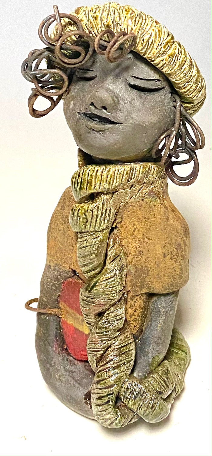 Meet Edna! Edna stands 6" x 3.5”x 4" and weighs  12.4 ozs.  She has a dark lovely smokey black complexion. Edna has a glossy green and copper metallic dress.  She clinches her designer  Dark red purse. Edna wears a designer hat as well. With the current situation we All are going through,  Edna will place a smile on your face during this challenging time.  If not return Edna within 30 days after receiving her for a complete refund.