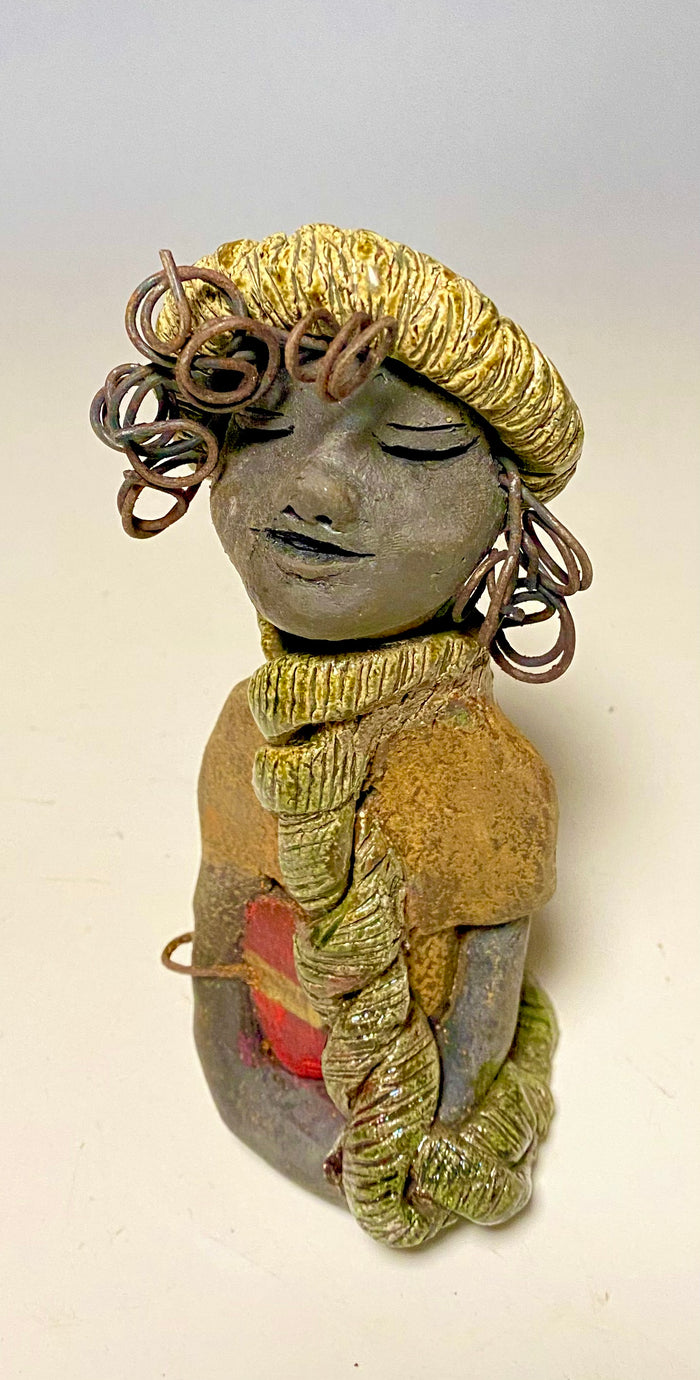 Meet Edna! Edna stands 6" x 3.5”x 4" and weighs  12.4 ozs.  She has a dark lovely smokey black complexion. Edna has a glossy green and copper metallic dress.  She clinches her designer  Dark red purse. Edna wears a designer hat as well. With the current situation we All are going through,  Edna will place a smile on your face during this challenging time.  If not return Edna within 30 days after receiving her for a complete refund.