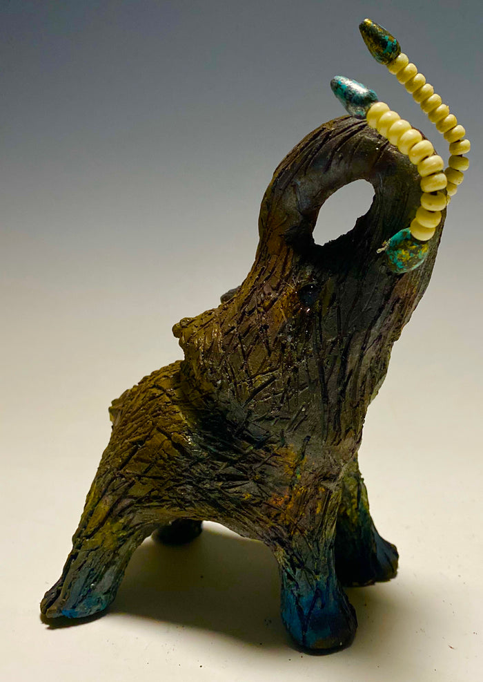 Have you HERD!!!!!!     Elephants are one of my favorite animals to create. They are so majestic"  Just one of these lovely Raku Fired Elephant will make an excellent gift for your  BFF,  or just for you .    This raku fired elephant stands 6" x 4" x 5" and weighs 1 lb. She has beaded tusks and a textured charcoal  and copper metallic body. This one is nice to add your Herdew Collection!