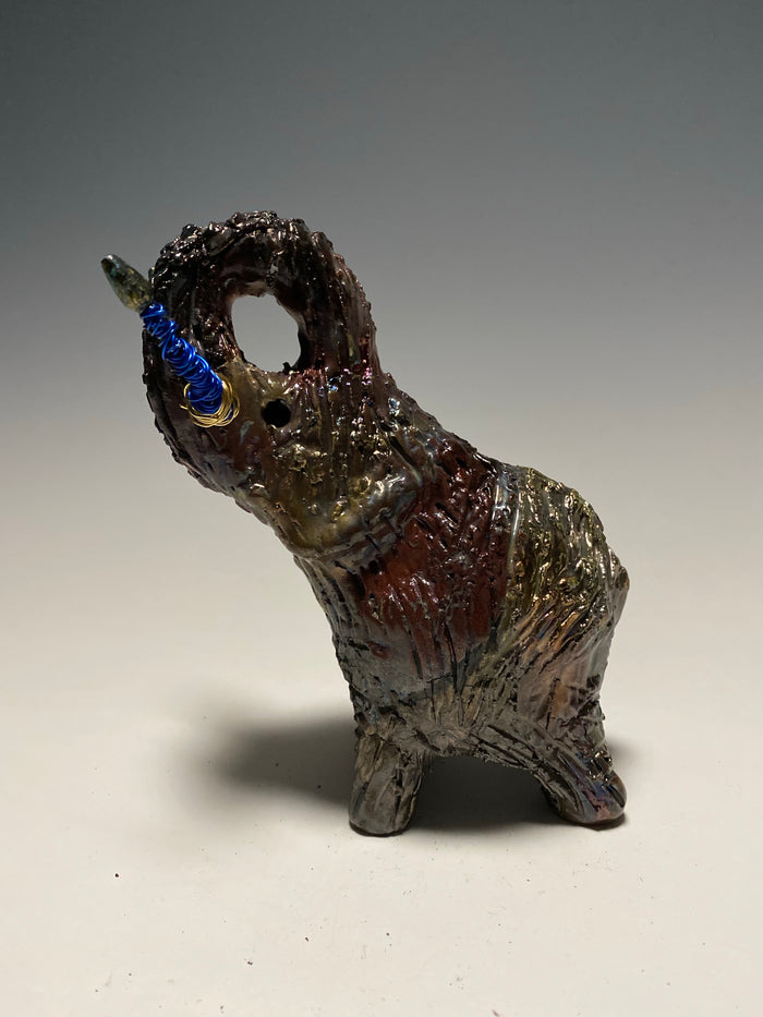 Raku Elephant Have you HERD!!!!!!  Just one of these lovely Raku Fired Elephant will make an excellent gift for your  friend, sorority or for your home’ special place centerpiece.   6" x 4" x 4" 1 lbs Beaded tusk with blue and gold wire Beautiful  colorful metallic raku elephant For decorative purposely only