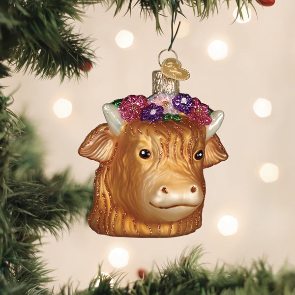 Floral Highland cow glass ornament with a flower crown hanging on a tree