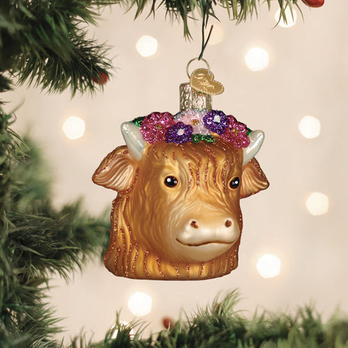Floral Highland cow glass ornament with a flower crown hanging on a tree
