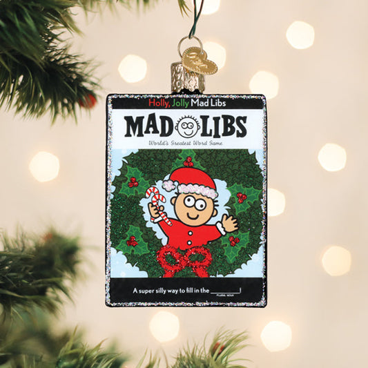 Holly Jolly Mad Libs book glass Christmas ornament hanging on a tree