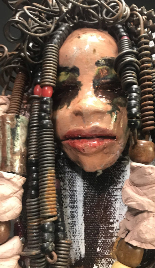Kamara is uniquely mounted on a painted 6"x 4"x 2" canvas. It weighs 1.6lbs.     Her face is formed with hand coiled wire, raku beads, textured brown cloth, and multi color raku beads.     Kamara's face beams with pale pink crackle glaze and ruby red lips.  Kamara is ready to be hung in a special place!