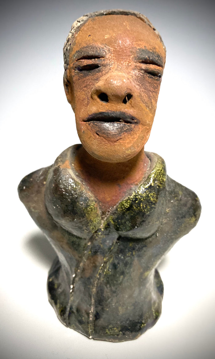 Mr. Charles has a story to tell!  Do you See the wisdom in his face? Mr. Charles  stands 5"x 3" x 2.5" and weighs 11 ozs. He wears a copper green metallic jacket. Mr. Charles's complexion is honey brown and he has salt and pepper hair.