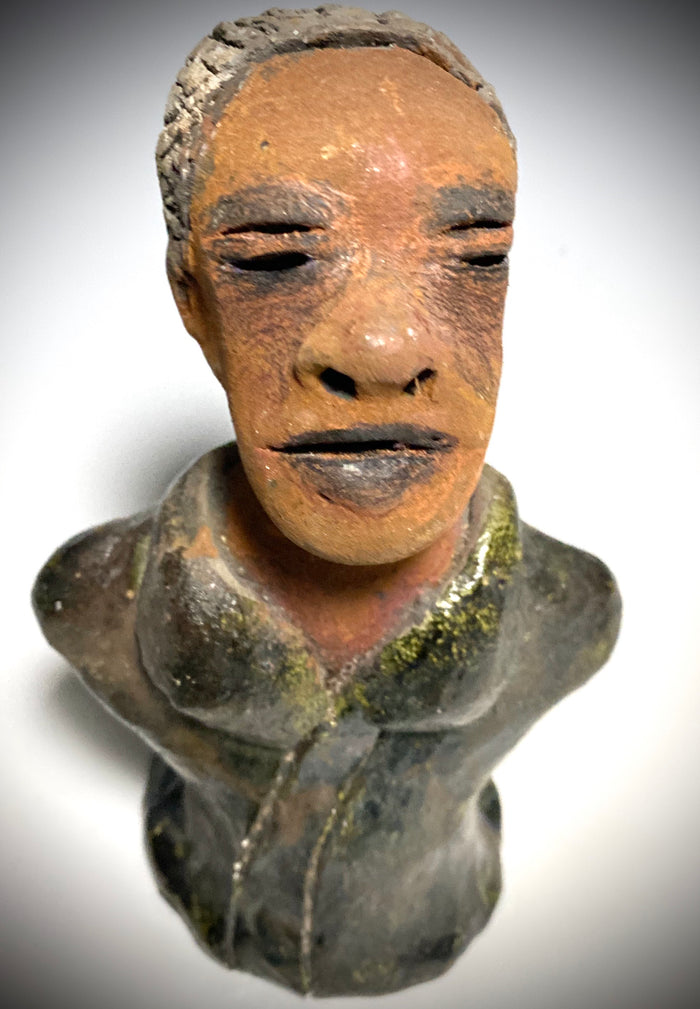 Mr. Charles has a story to tell!  Do you See the wisdom in his face? Mr. Charles  stands 5"x 3" x 2.5" and weighs 11 ozs. He wears a copper green metallic jacket. Mr. Charles's complexion is honey brown and he has salt and pepper hair.