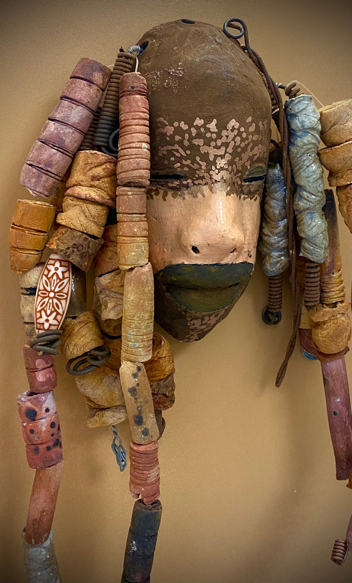 Meet Paul! At 80.00, I don't think Paul will stay here long! I started making art soon after seeing authentic African artwork at the Smithsonian Museum of African Art. I was in total awe.  Paul was inspired by my visit there.   Paul has a two tone complexion of black and dark metallic copper. He  is 6" x 14" and weighs 1 lbs. Paul has over 20 handmade earthy raku fired beads. Paul will look his best in a earthy or green background. Got Questions????