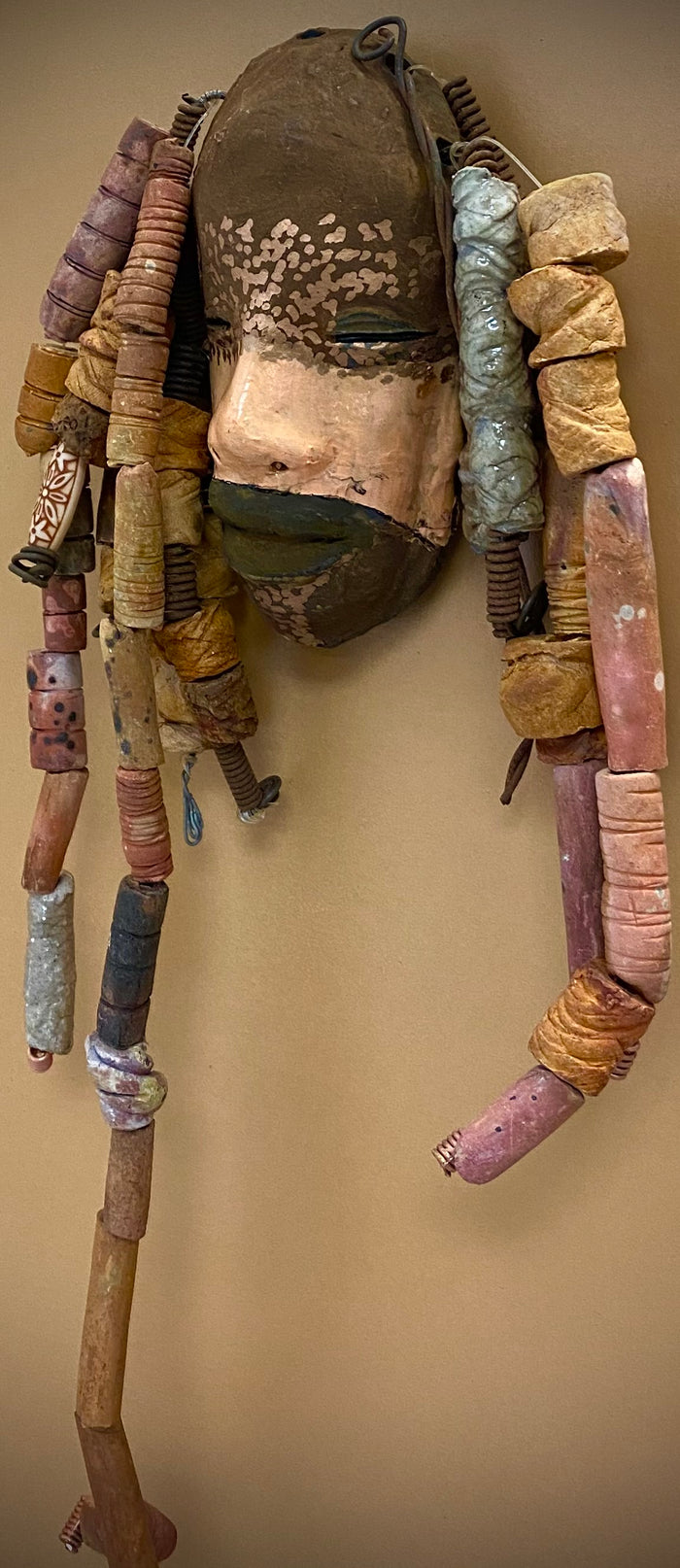 Meet Paul! At 80.00, I don't think Paul will stay here long! I started making art soon after seeing authentic African artwork at the Smithsonian Museum of African Art. I was in total awe.  Paul was inspired by my visit there.   Paul has a two tone complexion of black and dark metallic copper. He  is 6" x 14" and weighs 1 lbs. Paul has over 20 handmade earthy raku fired beads. Paul will look his best in a earthy or green background. Got Questions????