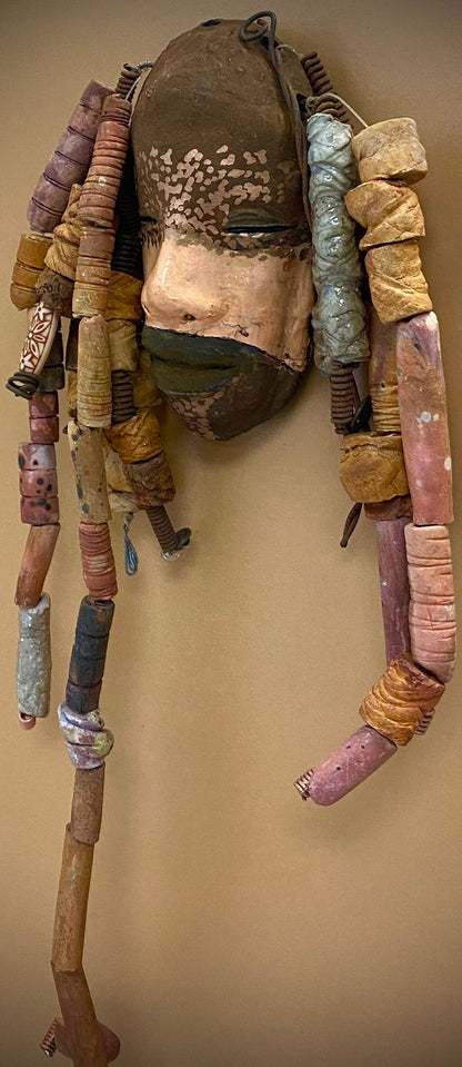 Meet Paul! At 80.00, I don't think Paul will stay here long! I started making art soon after seeing authentic African artwork at the Smithsonian Museum of African Art. I was in total awe.  Paul was inspired by my visit there.   Paul has a two tone complexion of black and dark metallic copper. He  is 6" x 14" and weighs 1 lbs. Paul has over 20 handmade earthy raku fired beads. Paul will look his best in a earthy or green background. Got Questions????