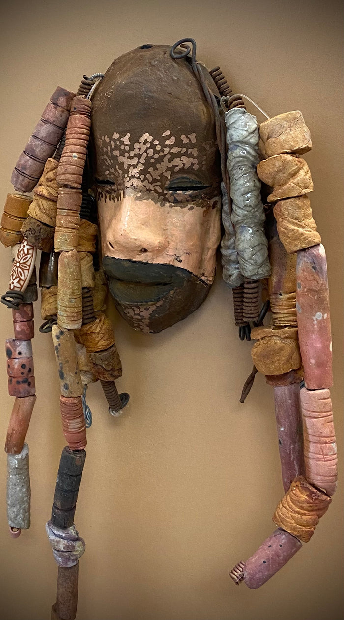 Meet Paul! At 80.00, I don't think Paul will stay here long! I started making art soon after seeing authentic African artwork at the Smithsonian Museum of African Art. I was in total awe.  Paul was inspired by my visit there.   Paul has a two tone complexion of black and dark metallic copper. He  is 6" x 14" and weighs 1 lbs. Paul has over 20 handmade earthy raku fired beads. Paul will look his best in a earthy or green background. Got Questions????