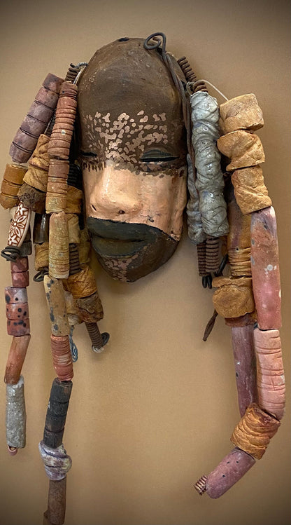 Meet Paul! At 80.00, I don't think Paul will stay here long! I started making art soon after seeing authentic African artwork at the Smithsonian Museum of African Art. I was in total awe.  Paul was inspired by my visit there.   Paul has a two tone complexion of black and dark metallic copper. He  is 6" x 14" and weighs 1 lbs. Paul has over 20 handmade earthy raku fired beads. Paul will look his best in a earthy or green background. Got Questions????