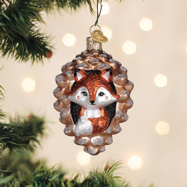 Piney fox glass ornament of a fox peeking from a pine cone