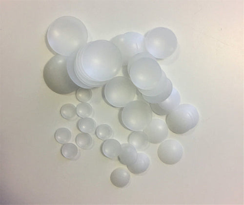 A collection of various sized transparent plastic domes arranged on a surface.