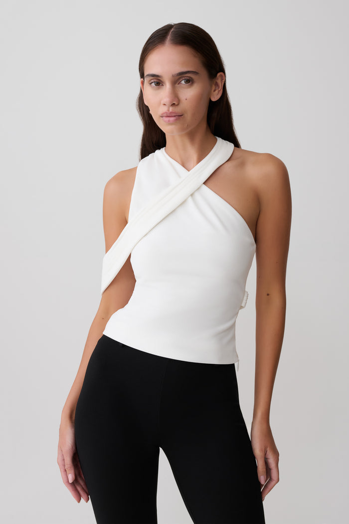 Woman wearing white crossover crepe halter top.