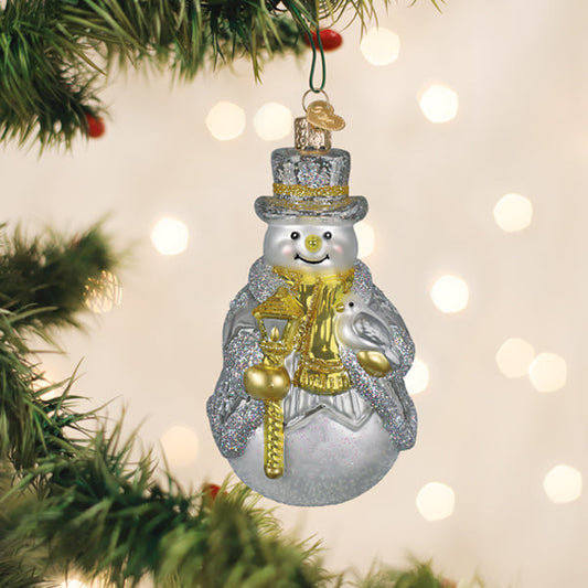 Sterling snowman glass ornament in glittered silver hanging on a tree